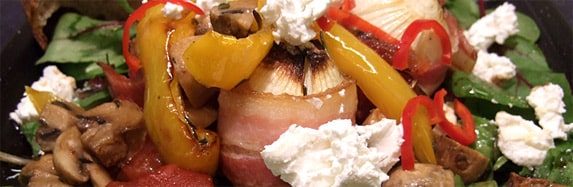 Speckzwiebeln auf Salatbett mit Gemüse aus dem Ofen