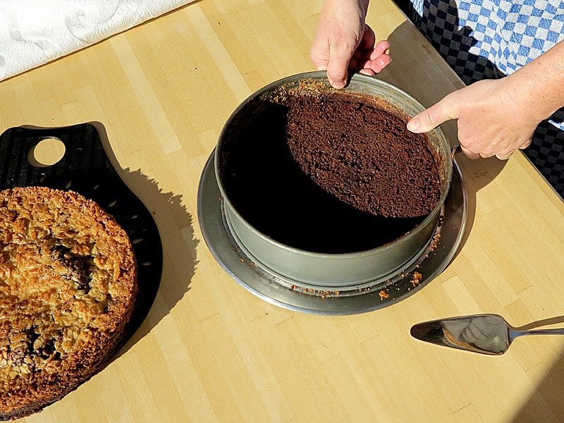 Den Kuchen quer halbieren, den oberen Teil (Deckel) beiseite legen. Den Rand der Springform wieder um den Boden legen und schließen